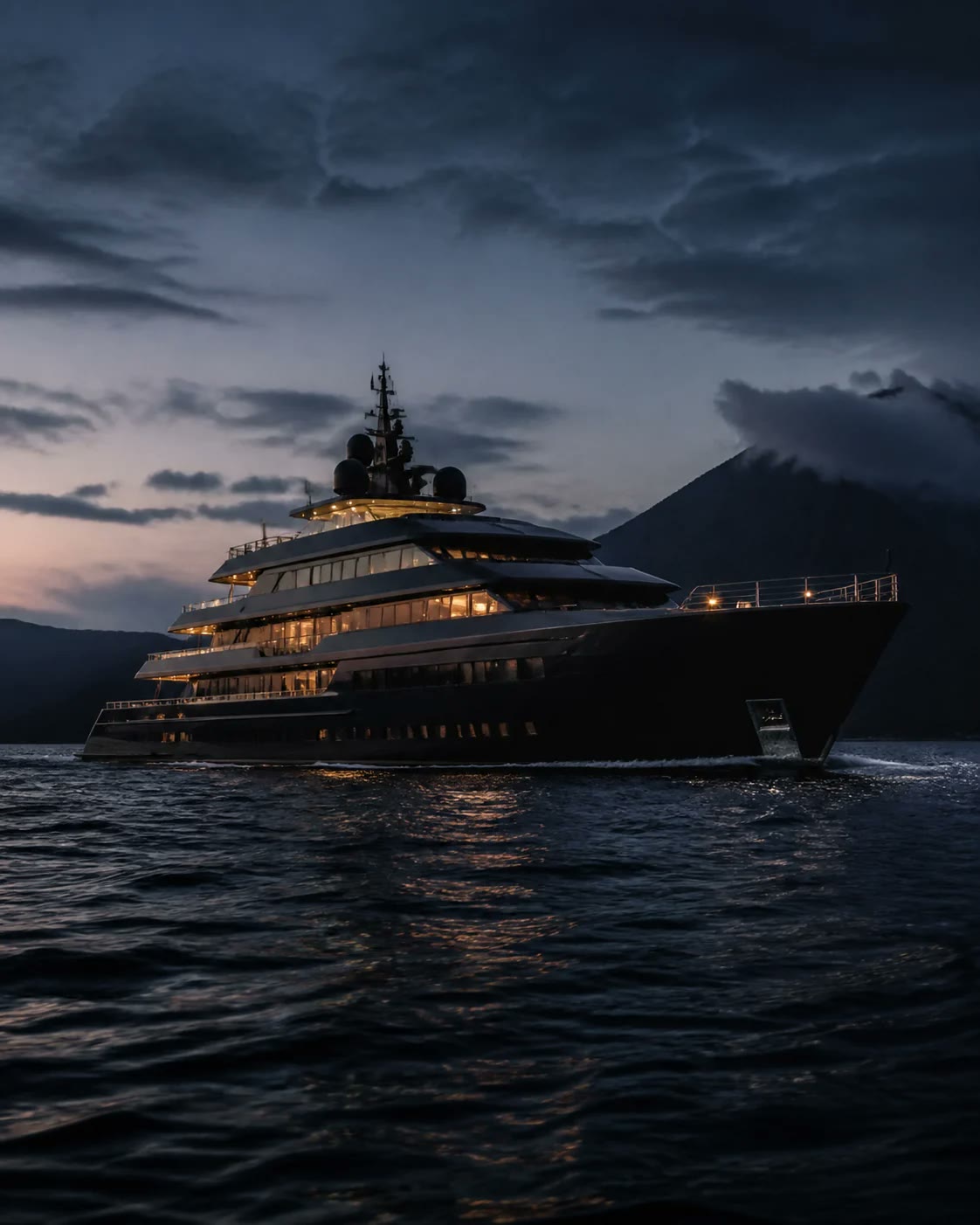 Superyacht at anchor under a dark evening sky