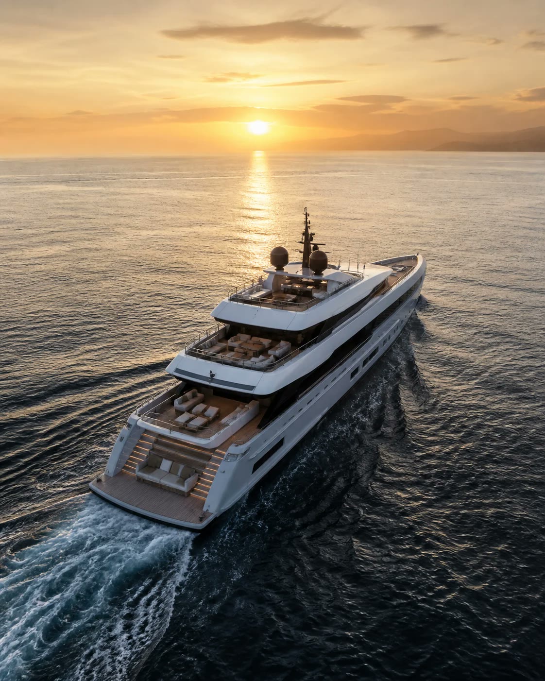 Superyacht underway on a golden sea, seen from above